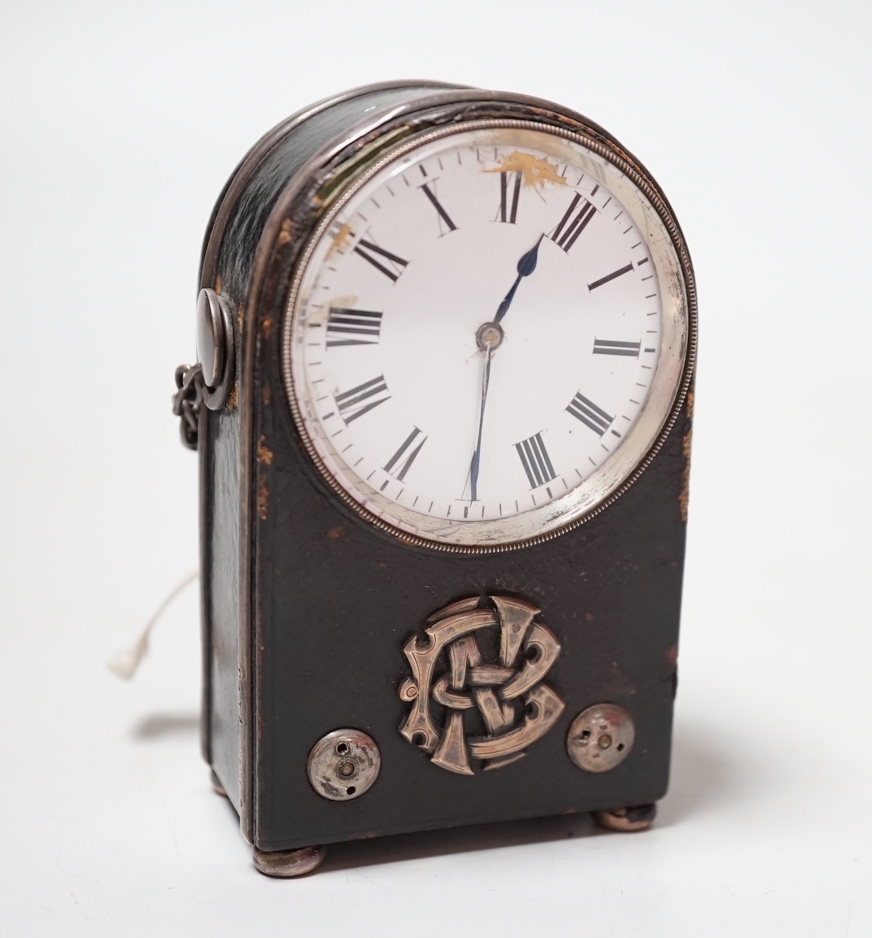 An unusual French White metal wall mounted black Morocco leather covered travelling timepiece, 9.5 cm high